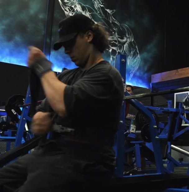 Sam putting on lifting straps before a set